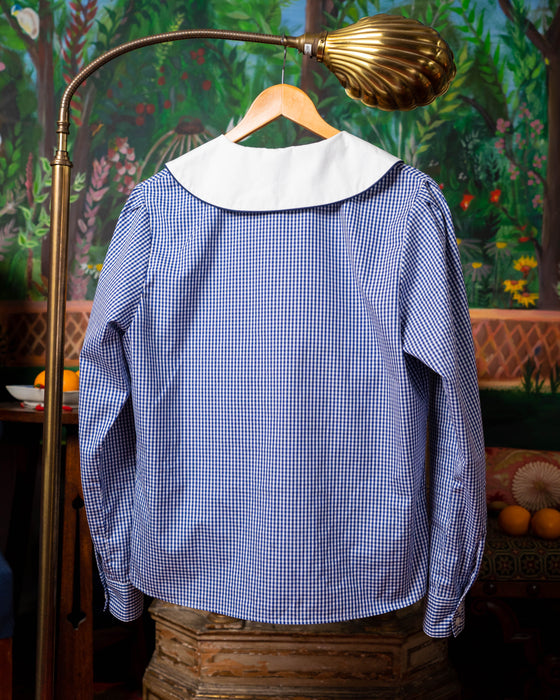 Back of shirt with puff shoulders and piped collar. Navy gingham, white collar, orange embroidery.